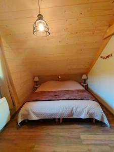 Cama en habitación con techo de madera en Au chalet de JO en Muhlbach-sur-Munster