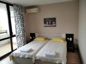 a bedroom with two twin beds and a window at Victoria's apartments Nesebar in Nesebar +22 photos