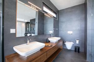 a bathroom with two sinks and a mirror and a toilet at Luxury Villa for 8 with 20m large Infinity Pool in Kalkan in Kaş +20 photos