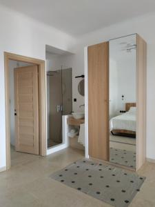 a bedroom with a bed and a shower and a mirror at Enalion residences in Tinos