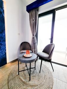 een woonkamer met 2 stoelen en een tafel bij Penélope Hotel in Ialyssos