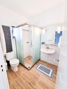 a bathroom with a shower and a toilet and a sink at Pen&eacute;lope Hotel in Ialyssos