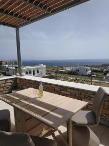 a table and chairs on a balcony with a view of the ocean at Enalion residences in Tinos