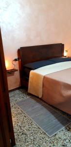 ein Schlafzimmer mit einem Bett und einer Lampe an einer Wand in der Unterkunft House & Garden in Marina di Massa