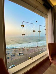 a window with a view of a beach and the ocean at Hyat Hostel & Suites in Alexandria