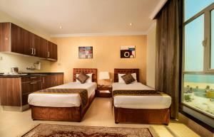 um quarto de hotel com duas camas e uma janela em Bravo Royal Hotel Suites em Kuwait