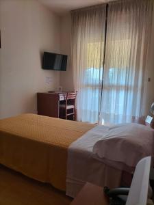 西爾米奧奈的住宿－德比酒店，酒店客房设有两张床、一张桌子和一台电视。