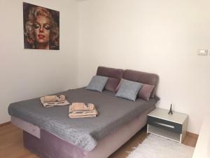 een bed in een kamer met een foto aan de muur bij Monro Apartment in Hévíz
