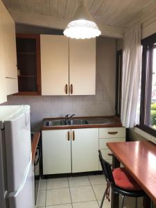 eine Küche mit einem Tisch und einem weißen Kühlschrank in der Unterkunft Casa di Taty - Home resort in Policoro