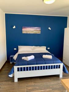 a blue bedroom with a bed with a blue wall at Appartamento Il Pomodoro in San Vito lo Capo