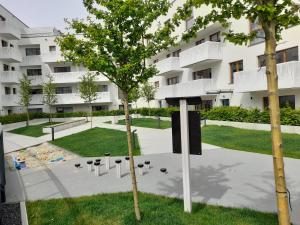 a tree in front of a building with a playground at Golden MOOD City Apartment in Wrocław