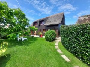 a yard with a house with a thatched roof at Gîtes la Conterie in Fatouville-Grestain