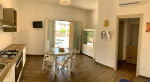 a kitchen with a table and a dining room at Appartamento Il Pomodoro in San Vito lo Capo