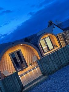 a round house with a wooden fence in front of it at Apex Studio Pod & Jacuzzi Bath in Fort William