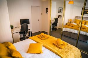 a bedroom with two beds with yellow sheets and a desk at Aunt Mary's in Belfast