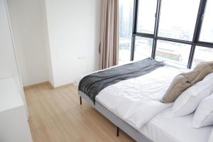 een bed in een kamer met een groot raam bij Entire apartment near BTS 2 bedrooms with view in Ban Song Hong