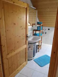 a bathroom with a wooden door and a sink at Antonia in Egling