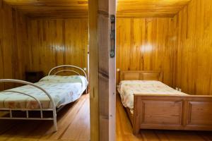 2 łóżka w pokoju z drewnianymi ścianami w obiekcie Maison a la Frontière Espagnole w mieście Arnéguy