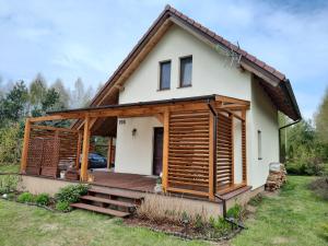 a house with a porch and a deck at Wycinki domek in Osiek