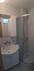 baño blanco con ducha y lavamanos en APARTMAN PAVE & ILIJA jr, en Lopar