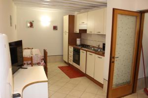 kuchnia z białymi szafkami i kuchenką w obiekcie CHIARA HOUSE VENICE w Wenecji