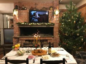 a christmas table with a christmas tree and a television at Hotel Kelmendi in Lëpushë