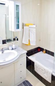 ein weißes Badezimmer mit einem Waschbecken und einer Badewanne in der Unterkunft Edifício Tomás in Ferragudo