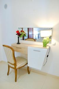 a desk with a chair and a mirror at Edifício Tomás in Ferragudo