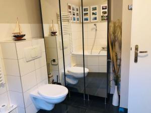 łazienka z 2 toaletami i prysznicem w obiekcie Waldidyll w mieście Neuzelle