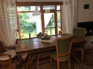 een eettafel met stoelen en een raam bij Waldidyll in Neuzelle