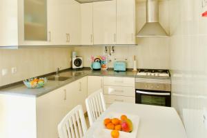 a kitchen with a table with fruit on it at Edifício Tomás in Ferragudo