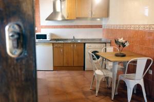 a kitchen with a wooden table and chairs and a table at LOFT NORDESTE in Lastres