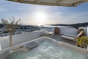 a hot tub on the balcony of a house at Sunset View Hotel in Parikia