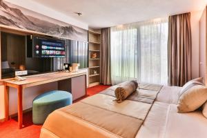 un ampio soggiorno con divano e scrivania di Carine Hotel Centar a Podgorica