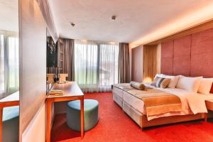 una camera d'albergo con un grande letto e un bagno di Carine Hotel Centar a Podgorica