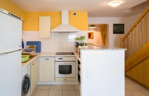 a kitchen with white appliances and yellow walls at Les Bains de Rosheim in Rosheim
