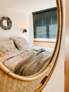 a bedroom with a bed in a round mirror at la MERéMOI - Duplex Knokke with balcony and free parking in Knokke-Heist