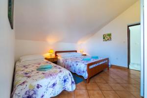 a bedroom with two beds and a window at Apartment Nada in Petrcane