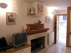 sala de estar con TV y chimenea en Casa Pasquina, en Rocca Sinibalda