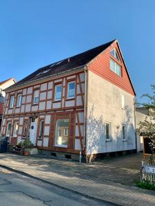 a house with a red and white building at 1-Zimmer-Wohnung Astfeld in Langelsheim