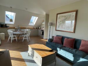 a living room with a blue couch and a table at Little Thistle Apartment in Whitebridge