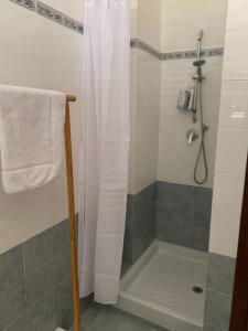 ein Bad mit einer Dusche mit einem weißen Duschvorhang in der Unterkunft Sicily Emotion in Giardini-Naxos
