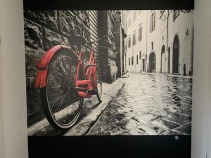 una bicicleta roja estacionada junto a un edificio de ladrillo en New Home Guest House, en Gödöllő