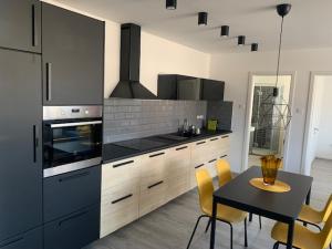a kitchen with a table and yellow chairs in a kitchen at New Home Guest House in Gödöllő