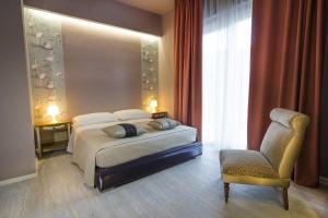ein Hotelzimmer mit einem Bett und einem Stuhl in der Unterkunft Bontempo Suite in Vasto