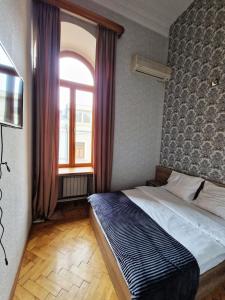 niewielka sypialnia z łóżkiem i oknem w obiekcie Friendly Hotel w mieście Tbilisi City