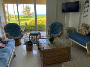 a living room with chairs and a couch and a tv at Playa Parguito Margarita in Aricagua