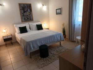 a bedroom with a large bed with white sheets and pillows at Apartman MAKA in Kučiće