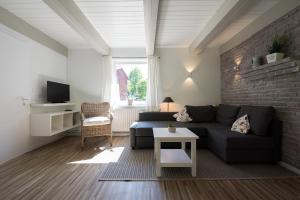 a living room with a blue couch and a brick wall at Krögerhof in Manhagen