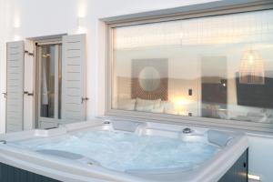 a large bath tub in a bathroom with a window at Sunset View Hotel in Parikia